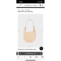 ราคา Charles Keith Ring Detail Curved Crossbody Bag in Chalk / สีครีม (47852159922)